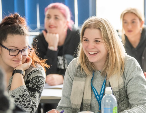 Two students sat at a table, both smiling.