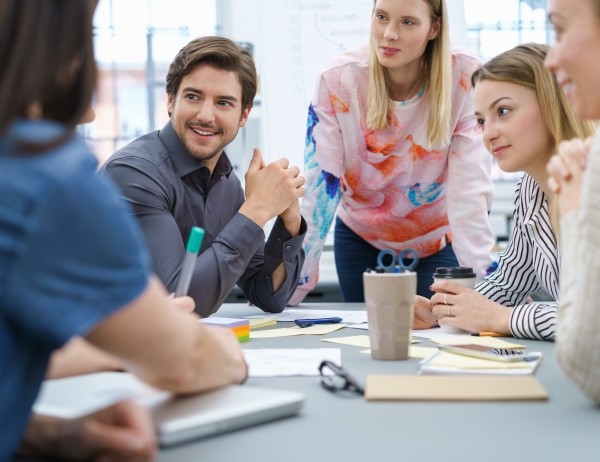 Five Chartered Manager Degree Apprenticeship students, grouped around a table in discussion.