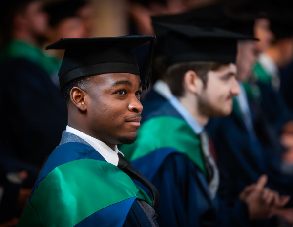 A close-up of a Higher Education graduate watching the ceremony.